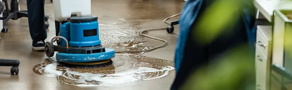 Reinigungskraft von cleanteam bei der professionellen Industriereinigung eines Hallenbodens in einem Produktionsbetrieb in der Region Ulm