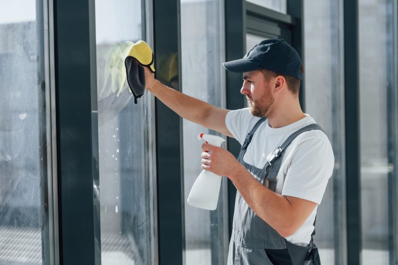 cleanteam-Fachkraft prüft Ergebnis nach Glasreinigung an Bürogebäude in Laupheim